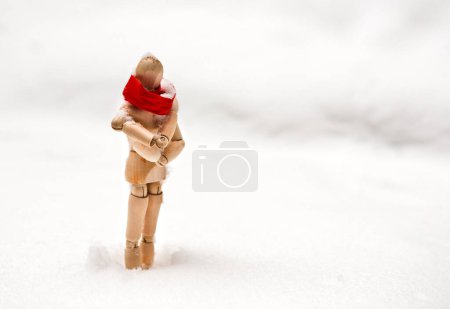 Photo for Small wooden puppet in snowdrift - Royalty Free Image