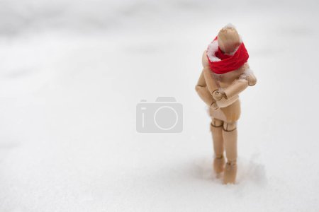 Photo for Small wooden puppet in snowdrift - Royalty Free Image