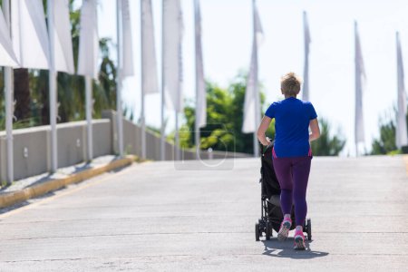 Téléchargez les photos : Maman avec bébé poussette jogging - en image libre de droit