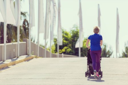 Téléchargez les photos : Maman avec bébé poussette jogging - en image libre de droit