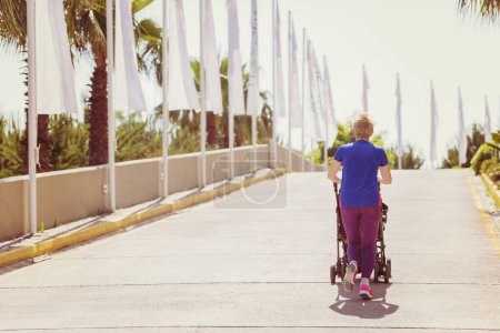 Photo for Mom with baby stroller jogging - Royalty Free Image