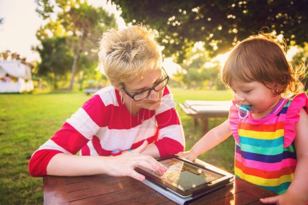 Téléchargez les photos : Maman et sa petite fille utilisant une tablette - en image libre de droit