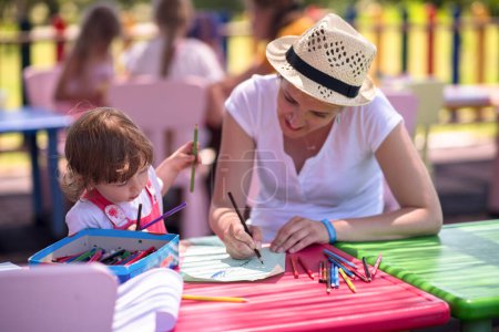 Téléchargez les photos : Maman et petite fille dessinent des images colorées - en image libre de droit