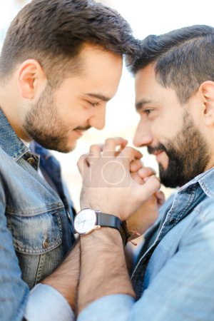 Photo for Portrait of young gays holding hands and wearing jeans shirts. - Royalty Free Image