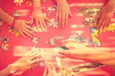 Foto de Vista superior de las manos de los niños jugando con rompecabezas - Imagen libre de derechos