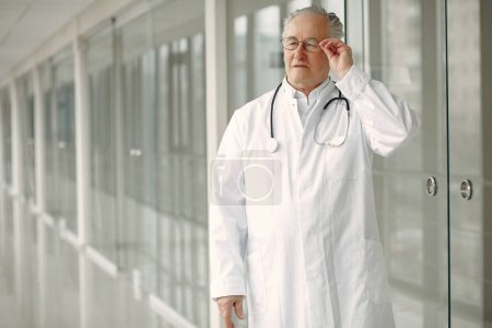 Téléchargez les photos : Vieux docteur en uniforme debout dans la salle - en image libre de droit
