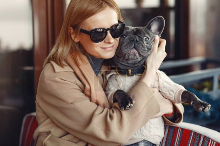 Photo for Elegant woman in a brown coat with black bulldog - Royalty Free Image