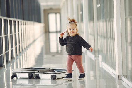 Foto de Niña con una maleta en el aeropuerto - Imagen libre de derechos