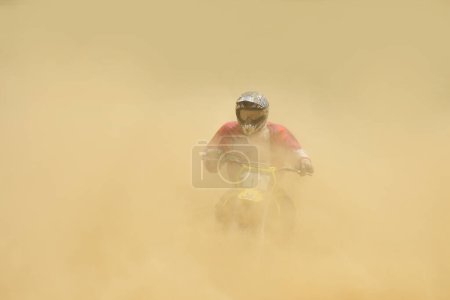 Téléchargez les photos : Motocross motard chevauchant dans la poussière de sable - en image libre de droit