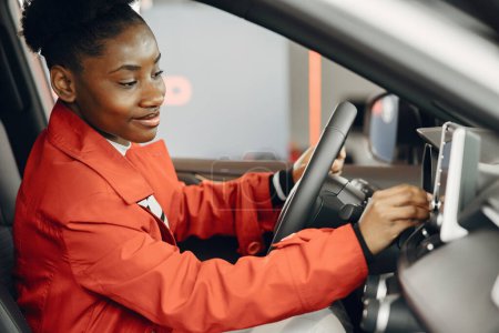 Photo for "Young african american woman in car salon" - Royalty Free Image
