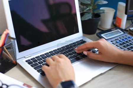 Téléchargez les photos : Femme mains appuyant sur les touches sur un clavier d'ordinateur portable dans le bureau - en image libre de droit