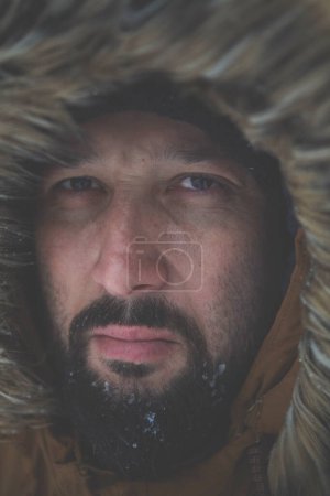 Téléchargez les photos : Homme à l'hiver par temps orageux portant une veste de fourrure chaude - en image libre de droit