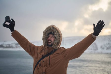 Téléchargez les photos : Photographe en hiver par temps orageux portant une veste de fourrure chaude - en image libre de droit