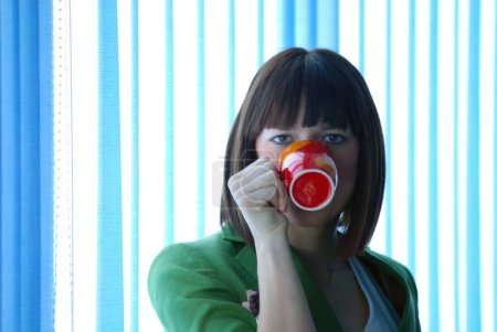 Foto de Mujer con taza de té pf en la oficina - Imagen libre de derechos