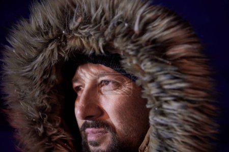 Foto de Hombre en invierno en la noche de clima tormentoso usando abrigo de piel caliente - Imagen libre de derechos