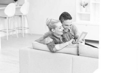 Téléchargez les photos : Couple relaxant à la maison avec tablettes - en image libre de droit