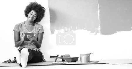 Foto de Negro pintor femenino sentado en el suelo - Imagen libre de derechos
