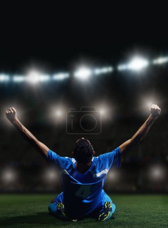 Téléchargez les photos : Joueur de football en face du grand stade moderne avec des fusées éclairantes et des lumières - en image libre de droit