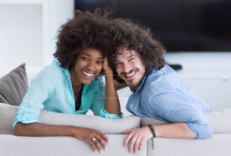 Téléchargez les photos : Jeune couple multiethnique dans le salon - en image libre de droit