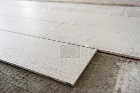 Photo for Ceramic wood effect tiles and tools for tiler on the floor - Royalty Free Image