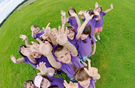 Téléchargez les photos : Groupe d'enfants heureux ont plaisir dans la nature - en image libre de droit