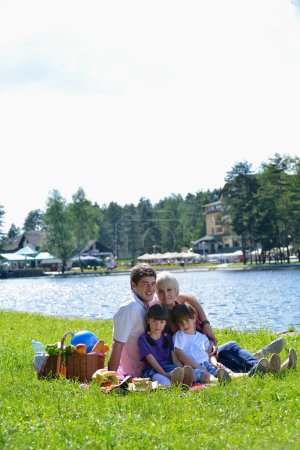 Téléchargez les photos : Famille heureuse jouant ensemble dans un pique-nique en plein air - en image libre de droit