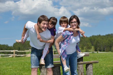 Téléchargez les photos : Heureuse jeune famille avoir du plaisir en plein air - en image libre de droit