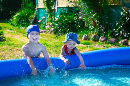 Téléchargez les photos : Frère et sœur jouant près de la piscine gonflable - en image libre de droit