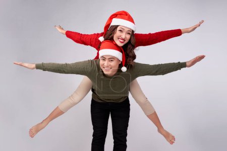 Photo for "Beautiful love asian couple having piggybacking for Christmas holidays." - Royalty Free Image