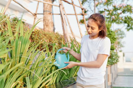 Téléchargez les photos : Belle fille asiatique arrosant les plantes - en image libre de droit