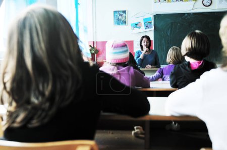 Téléchargez les photos : Enfants heureux avec professeur dans la classe de l'école - en image libre de droit