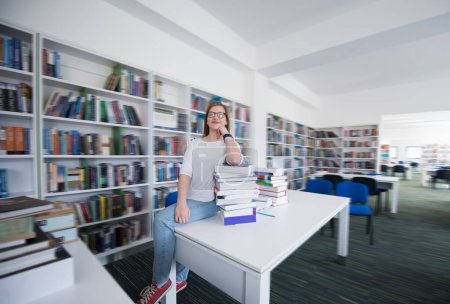 Photo for Female student study in library, using tablet and searching for information on internet - Royalty Free Image