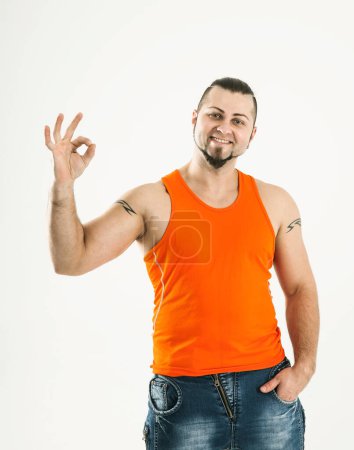 Téléchargez les photos : "portrait d'un sportif - bodybuilder en jeans et un shir orange" - en image libre de droit