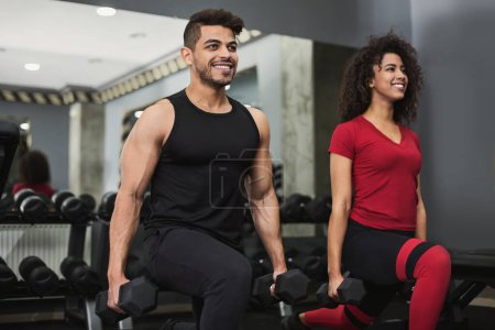Foto de Diverso entrenamiento de pareja con pesas en el gimnasio - Imagen libre de derechos