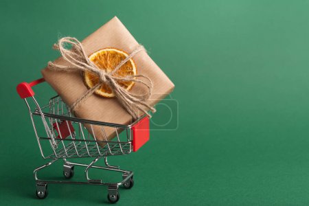 Photo for Paper parcel decorated with dried orange in shopping cart - Royalty Free Image