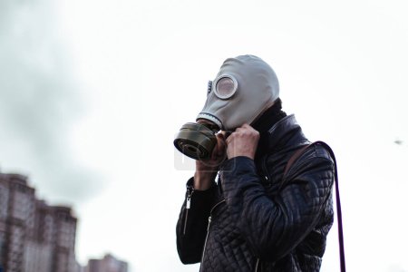 Photo for "young man wearing a gas mask on a city street" - Royalty Free Image