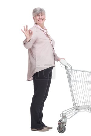 Foto de Anciana con un carrito de compras mirándote con una sonrisa. - Imagen libre de derechos