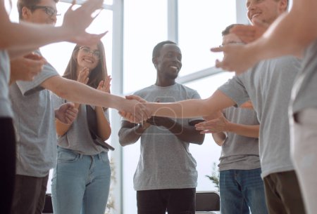 Photo for "young people shaking hands, standing in a circle of friends." - Royalty Free Image