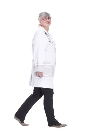 Photo for Happy woman doctor confidently striding forward. side view." - Royalty Free Image