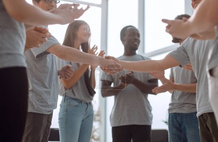 Photo for "young people shaking hands, standing in a circle of friends." - Royalty Free Image