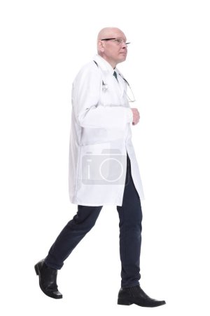 Téléchargez les photos : Homme médecin marche en avant avec confiance. isolé sur un blanc - en image libre de droit