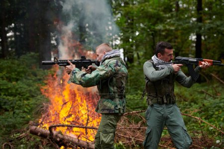 Foto de Dos soldados en acción con armas en el bosque - Imagen libre de derechos