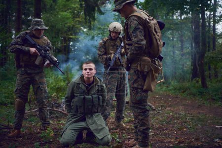 Téléchargez les photos : Interrogatoire de l'homme dans la forêt par des soldats - en image libre de droit
