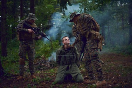 Foto de Interrogatorio del hombre en el bosque por soldados - Imagen libre de derechos