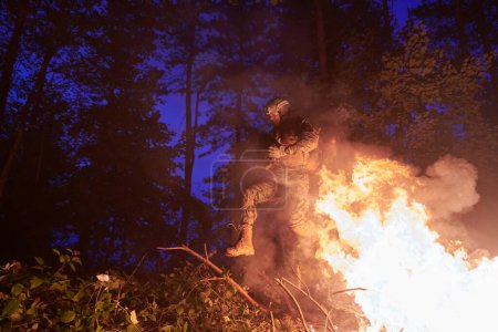 Foto de Soldado en acción por la noche saltando sobre el fuego - Imagen libre de derechos
