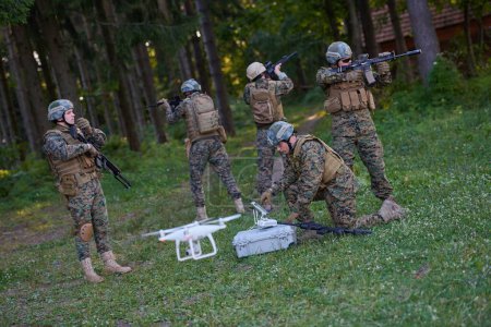 Téléchargez les photos : L'escouade de soldats utilise un drone pour repérer - en image libre de droit