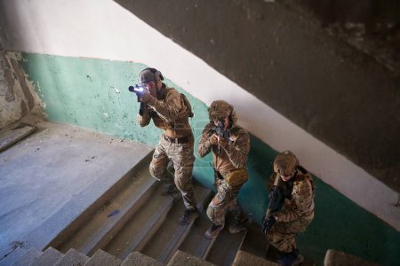 Téléchargez les photos : Guerre moderne soldats monter les escaliers dans le combat - en image libre de droit