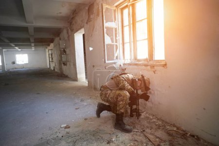 Foto de Soldado en acción cerca de la ventana cambiante revista y cubriéndose - Imagen libre de derechos
