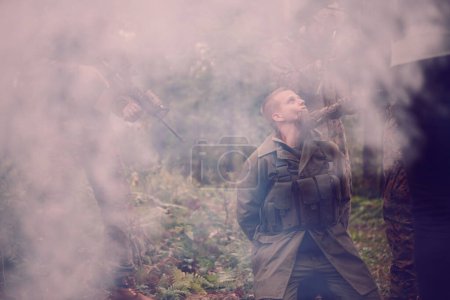 Photo for Interrogation of man in forest by soldiers - Royalty Free Image
