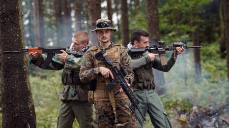 Foto de Grupo de soldados en uniforme militar sosteniendo rifles en el bosque - Imagen libre de derechos